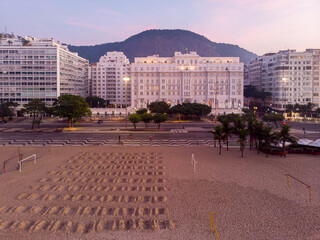 Symbolic graveyard with hundred graves dug on the beach in front of Copacabana palace as a protest...