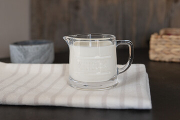 A glass  jar with milk on a table