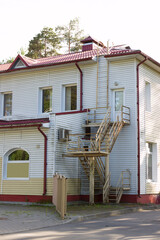 Fire emergency escape ladder, External emergency exit with a staircase behind a roadside two-story...