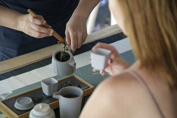 Chinese Tea Ceremony experience. Exquisite hot tea at traditional Chinese Tea Ceremony.  Caucasian woman participating in a traditional tea ceremony class. 