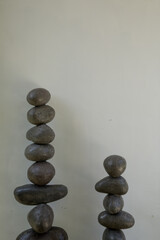 Stability and zen balanced stone tower against white wall