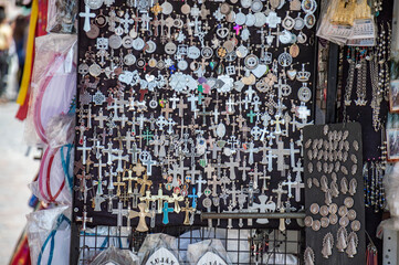 Many crosses and medals of virgins at a street vendor stall in Lujan, Buenos Aires, Argentina