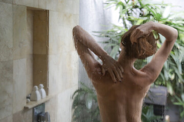 Young beautiful woman taking shower in bathroom	