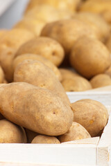 Heap of potatoes in wooden box, healthy nutrition concept