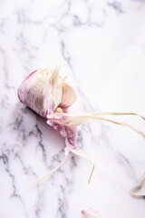 Raw garlic bulbs on white marble table. Fresh peeled garlic
