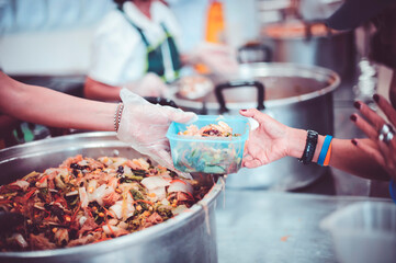 Providing free food to the poor : Volunteers scooping out food to give charity to those who are hungry