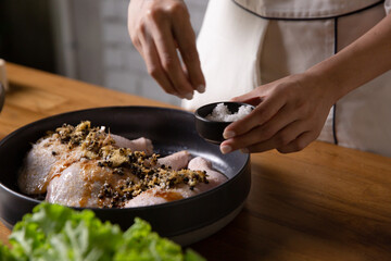 The chef cooks marinated chicken in his kitchen.