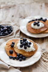 Oatmeal pancakes with yogurt and blueberries in white rustic tab