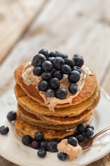 Stack of oatmeal pancakes topped with hazelnut paste and blueber