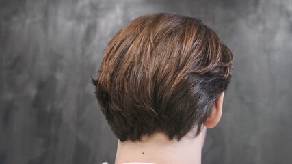 Young man posing after cutting and hairstyling in hair salon. Close up