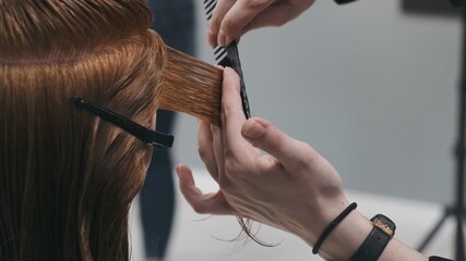 Stylist hair cutting with scissors on mannequin head, practices and training
