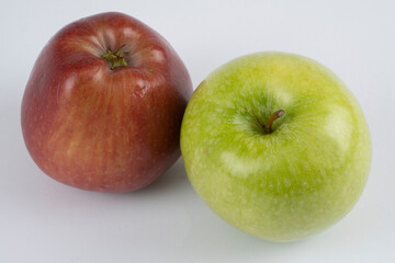 Green and red apples on a white background near each other