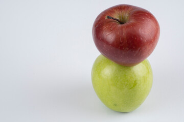 Green and red apples on a white background near each other