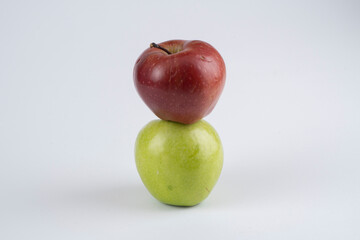 Green and red apples on a white background near each other