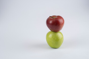 Green and red apples on a white background near each other