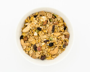 Bowl of granola with nuts, oats and raisins on white background