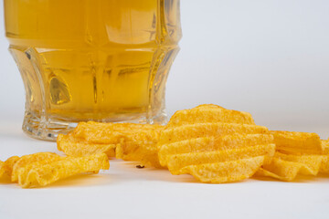 Glasses with beer and chips on a white background