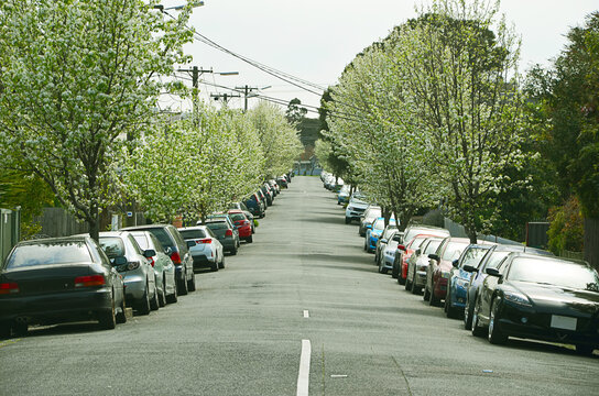 Suburban street with many cars parked in line on both sides of the road. Footscray, Melbourne Victoria, Australia