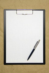 A tablet with a white sheet of A4 format on a beige craft paper.