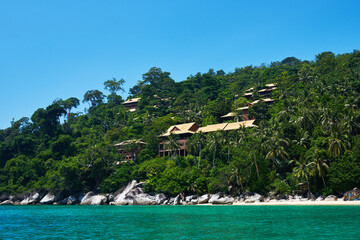 Luxury tropical vacation resort. Beach with white sand and picturesque rocks. Clear turquoise ocean. Mountain rainforest with a tropical resort. Perfect getaway. Travel, vacantion concept.