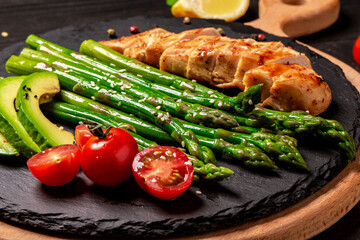 Baked chicken garnished with asparagus and tomatoes. Food recipe background. Close up. Turkish cuisine concept