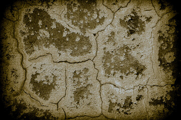 An abstract, old, cracked concrete wall with vignettes around the edges.