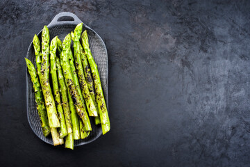 Traditioneller gegrillter grüner Spargel mit Kräuter als Draufsicht auf einem Modern Design...