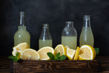 bottles with lemonade and ripe cut lemons