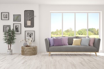 White living room with sofa and summer landscape in window. Scandinavian interior design. 3D illustration