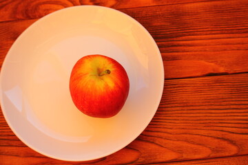 red ripe apple in a white plate