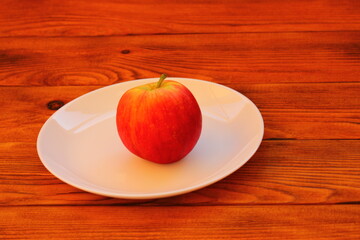 red ripe apple in a white plate