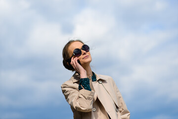 Young beautiful businesswoman with sunglasses, phone, laptop, cup of coffee in the city streets.