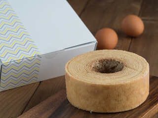 Baumkuchen, translated as tree cake, is a many-layered sponge cake baked on a rotating cylinder close-up on the table. horizontal 