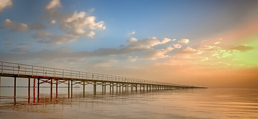 Naklejka premium a long bridge goes far into the sea