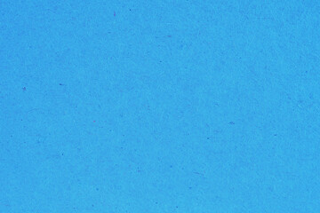 The surface of a sheet of blue or azure cardboard. Rough natural paper texture with cellulose...