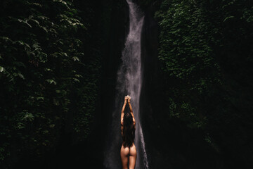 young woman backpacker looking at the waterfall in jungles. Ecotourism concept image travel girl