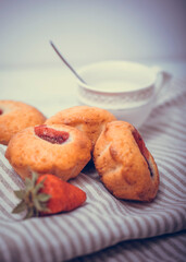 Strawberry muffin with fresh strawberries in a cut on a white wooden table.