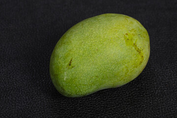 Green tasty mango over wooden background