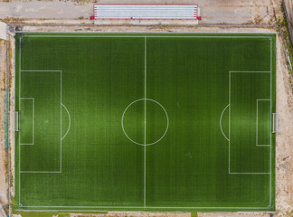 Top down drone view of a football field on the outskirts of a village