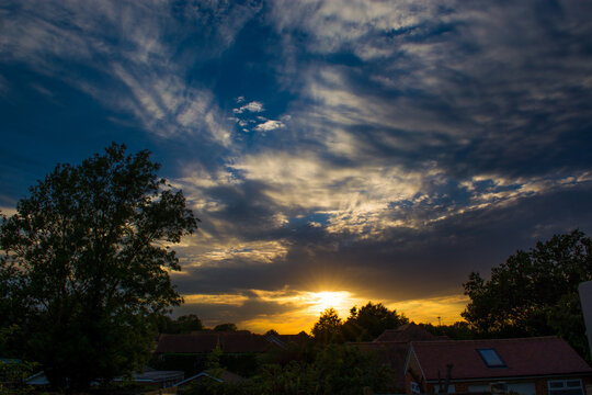 Beautiful sky at sunset over a rural village skyline.