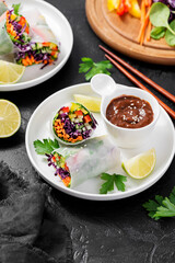 Vegetarian vietnamese spring rolls with peanut butter sauce, carrot, cucumber, red cabbage and rice noodle. Vegan food. 
