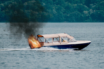 The boat is burning. The boat's engine caught fire. Motor boat used for tourist tours