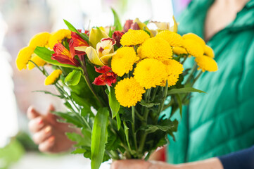 The work of the florist. Flower packaging. Creating a flower bouquet. Roses in a package. The hands of the florist. Selective focus. 