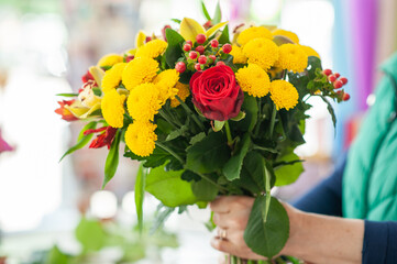 The work of the florist. Flower packaging. Creating a flower bouquet. Roses in a package. The hands of the florist. Selective focus. 