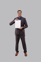 Businessman Holding Clipboard Watching in Camera Isolated. Indian Business man Standing Full Length with Clipboard in Hands