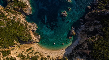 Fototapeta na wymiar Tranquil drone top down show of an isolated beach with moored boats at Corfu island in Greece