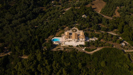 Fototapeta na wymiar Drone shot of a luxurious mansion with a swimming pool at the top of a mountain at Corfu island in Greece