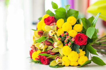 The work of the florist. Flower packaging. Creating a flower bouquet. Roses in a package. The hands of the florist. Selective focus. 