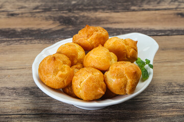 Sweet tasty profiteroles heap in the bowl