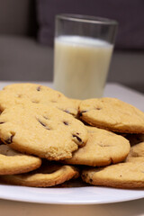 Chocolate chip cookies perspective close up. with a glass of milk on the background